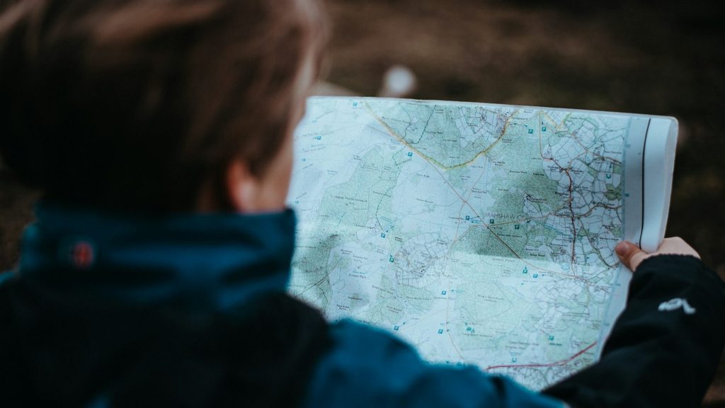 Una persona que consulta un mapa para ajustar el itinerario de un viaje.